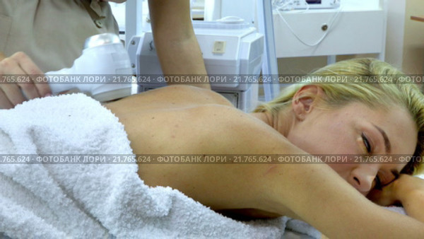 Young woman receiving electric back massage. Стоковое видео, видеограф Gennadiy Poznyakov / Фотобанк Лори
