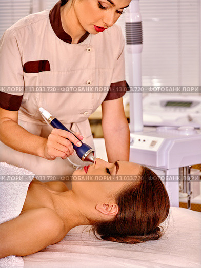 Young woman receiving electric ultrasonic facial massage. Стоковое фото, фотограф Gennadiy Poznyakov / Фотобанк Лори