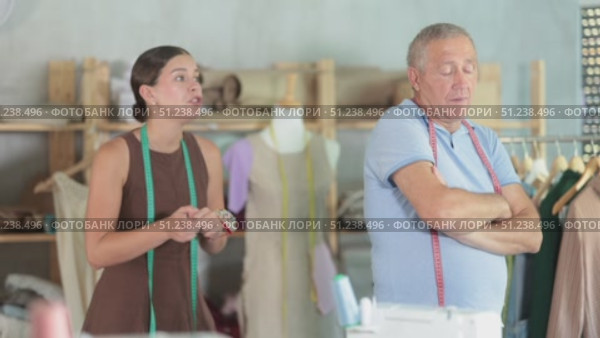 Young woman scolding elderly man in sewing workshop. Стоковое видео, видеограф Яков Филимонов / Фотобанк Лори