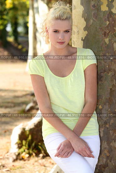 Young woman standing by a plane tree. Стоковое фото, агентство Ingram Publishing / Фотобанк Лори