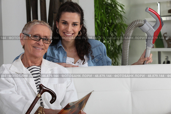 Young woman vacuuming for an elderly lady. Стоковое фото, агентство Ingram Publishing / Фотобанк Лори