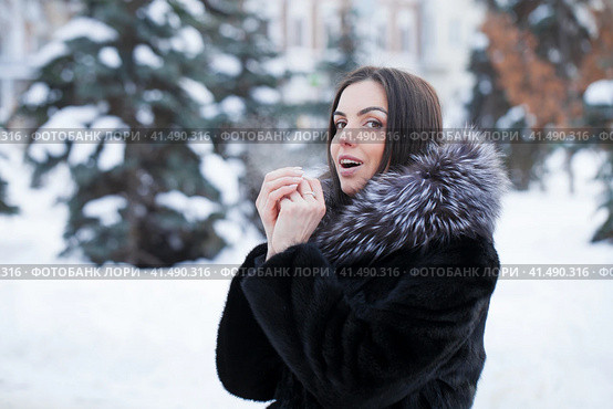 Young woman warms her palms with her breath in the frosty weather of her palms. Стоковое фото, фотограф Андрей Аркуша / Фотобанк Лори