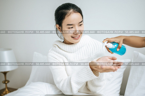 Young women clean their hands with a hand wash gel to prevent germs. Стоковое фото, агентство Ingram Publishing / Фотобанк Лори