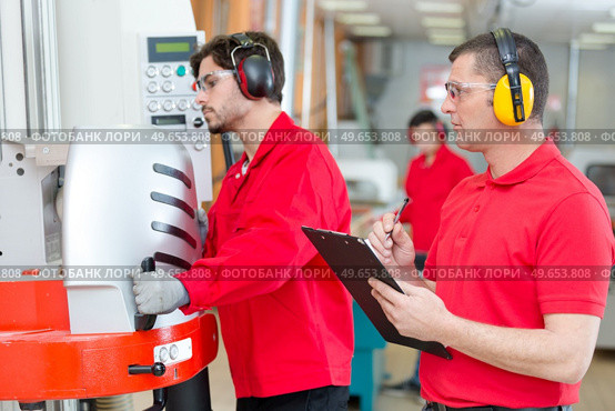 young worker being assessed using machinery in workshop. Стоковое фото, агентство Ingram Publishing / Фотобанк Лори