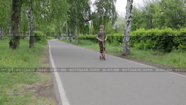 Забавный мальчик катится на самокате на камеру. Стоковое видео, видеограф Круглов Олег / Фотобанк Лори