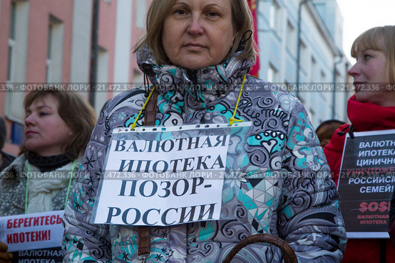 Заемщики валютной ипотеки участвуют в протесте против политики банков во время шествия КПРФ по улице Петровка в центре города Москвы, Россия (2015 год). Редакционное фото, фотограф Николай Винокуров / Фотобанк Лори
