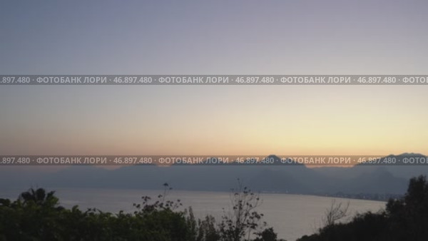 Закат над Анталией, у средиземного моря и горами Бейдаглары. Величественный закат над Анталией с видом на горы Бейдаглары, которые являются частью Таврского хребта. Мягкие оттенки неба гармонично сочетаются с силуэтами гор и побережьем Средиземного моря. Стоковое видео, видеограф Анна Чижова / Фотобанк Лори
