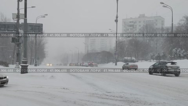 Заснеженная городская дорога. Автомобили едут по шоссе во время сильного снегопада. Снежная буря в городе зимой. Замедленная съемка, слоумо. Стоковое видео, видеограф Ирина / Фотобанк Лори