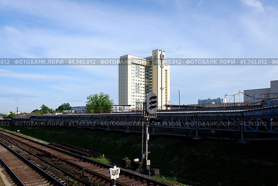 Здание ГУУ и железнодорожный светофор, Выхино, Москва. Moscow - June 7, 2021. Entrance signal of Vykhino underground station with the building of the State University of Management in background. Sunny summer view. Стоковое фото, фотограф Александр Кузнецов / Фотобанк Лори