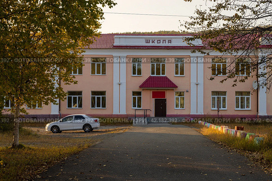 Здание школы. На фасаде надпись на русском языке «Школа». Пустой школьный двор. Школьное образование в России. Осенний сезон. Поселок городского типа Палатка, Магаданская область, Сибирь, Дальний Восток России. Стоковое фото, фотограф Андрей Степанов / Фотобанк Лори
