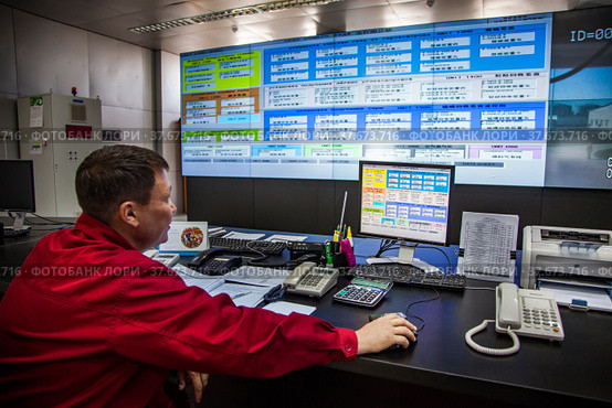 Zhanazhol, Aktobe region, Kazakhstan - May 04 2012: Oil refinery plant. Operation control room (center). Operator in red work wear monitoring processes. CNPC company. Редакционное фото, фотограф Alexey Rezvykh / Фотобанк Лори