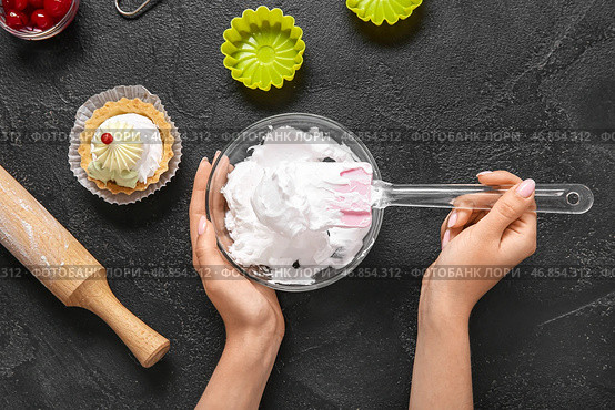 Женщина-кондитер готовит вкусные торты на черном фоне. Стоковое фото, фотограф Pixel_shot / Фотобанк Лори
