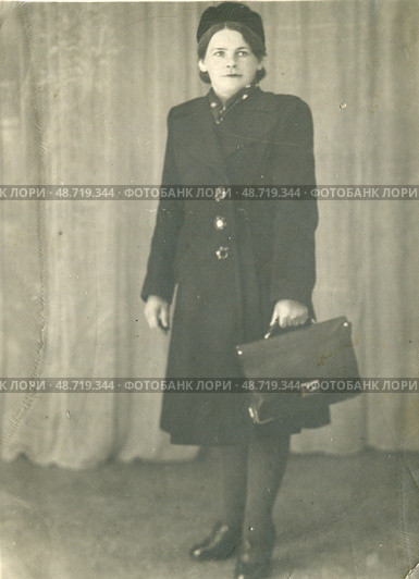 Женщина в строгом пальто с портфелем на фоне шторы, 1950-е гг. Стоковое фото, фотограф Retro / Фотобанк Лори