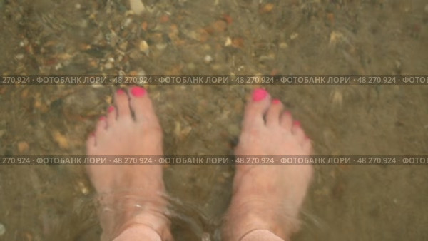 Женские ноги на песке в морской воде, небольшие морские волны. Стоковое видео, видеограф Надежда Глазкина / Фотобанк Лори