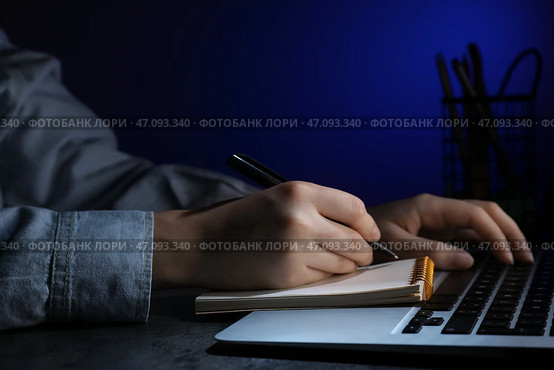 Женские руки держат ручку и работают с современным ноутбуком поздно ночью. Стоковое фото, фотограф Pixel_shot / Фотобанк Лори