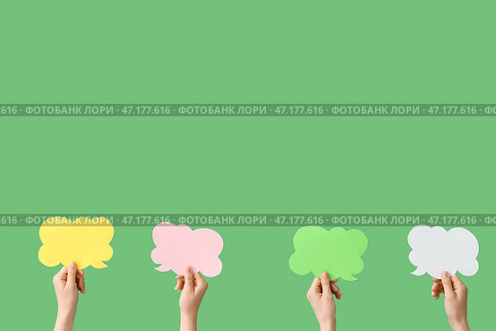Женские руки с облачками речи на зеленом фоне. Стоковое фото, фотограф Pixel_shot / Фотобанк Лори