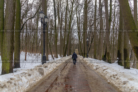 Зимой на дорожках городского парка образуются лужи от растаявшего снега. Заледеневшие дорожки для прогулок в зимнем парке. Зимой деревья стоят без листьев. Парк в Царицыно. Стоковое фото, фотограф Эдуард Белкин / Фотобанк Лори